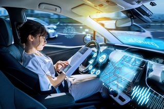 Woman reading in autonomous car,  driver assistance systems ADAS | DXC Technology 