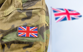 UK soldier's arm with flag in background, Intelligent Collaboration| DXC Technology Customer Story